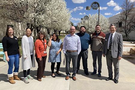 Brandon Fercik standing with Trio Center and KSJE Staff members